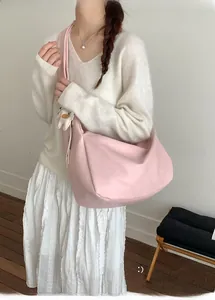 Detail of light pink oversized tote bag with soft leather texture and cute dog charm