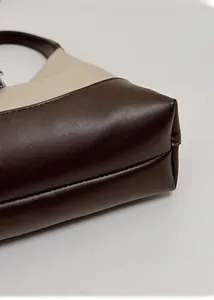 Detail shot of the reinforced base and precise stitching on the retro contrast handbag