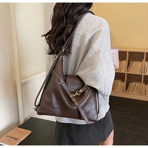Détail du sac cabas en cuir marron foncé avec boucle dorée et bandoulière réglable