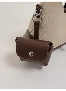 Detail of lychee pattern handbag with a brown detachable mini pouch and silver ring buckle