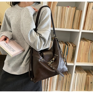 Vue détaillée d'un sac à bandoulière marron en cuir avec boucle de ceinture élégante