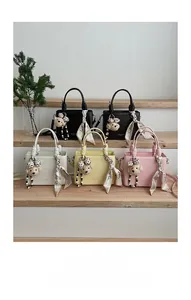 Detailed view of leather handbags with spiral woven handles and cute bear charms