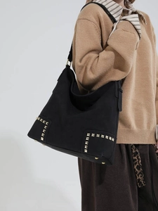 Borsa Hobo nera in camoscio con borchie dorate quadrate indossata da modella