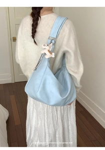 Light blue large capacity tote bag with white horse charm accessory on shoulder strap