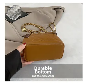 Macro view of the wear-resistant flat bottom on a brown quilted faux leather mini bag