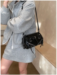 Detail of black patent leather Boston bag featuring silver metal zippers and D-rings
