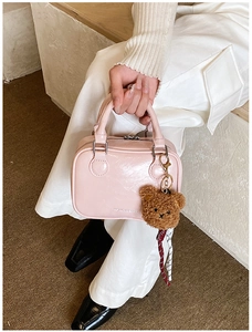 Détail du sac rose clair en similicuir avec plis naturels et charmant ours en peluche