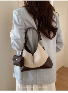 Detail view of contrast color retro shoulder bag with a small square coin purse attachment