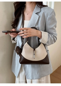 Detail showing retro hobo bucket bag with cream pebbled leather and silver piston buckle