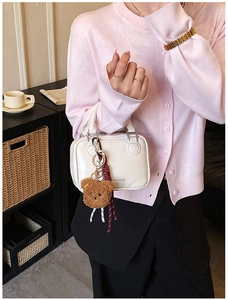 Détail du mini sac carré en cuir blanc avec un ours en peluche marron et impression latérale