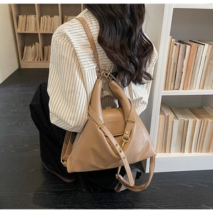 Vue détaillée du sac à dos en cuir kaki avec boucles dorées et forme géométrique
