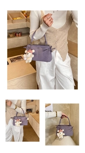 Detail of purple matte leather handbag with plush bear charm and side ribbon drawstring