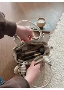 Interior view showing spacious compartments and zip pocket of beige knotted handle handbag