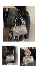 Detail of silver metallic motorcycle bag with studs, tassels and adjustable strap