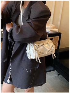 Detail of off-white Boston bag featuring dual zip pockets and long leather tassels