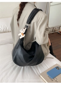 Black large capacity half-moon shoulder bag shown on model with a white pony charm