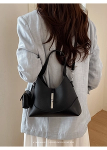 Detail of black lychee leather bag with silver buckle and matching small coin purse attachment