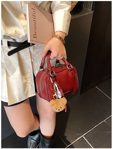 Détail du mini sac Boston en cuir verni rouge avec double zip et charm ours mignon
