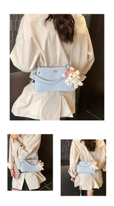 Close-up of light blue leather handbag with cute teddy bear charm and metal logo