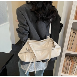 Detail of adjustable strap and silver zipper on a creamy white large tote bag