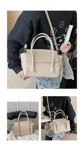 Detail of beige textured leather handbag showing sturdy handles and flap closure