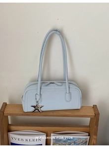 Detail of light blue bowling bag featuring dual zippers and a silver starfish charm