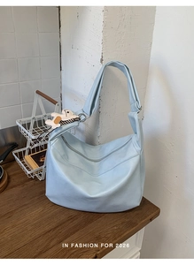 Close-up of a light blue large capacity tote bag with a cute puppy keychain detail