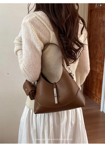 Rear view of model wearing a brown lychee leather crescent shoulder bag with coin pouch