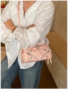 Pink glossy Boston bag detail featuring silver zippers and stylish tassel accents
