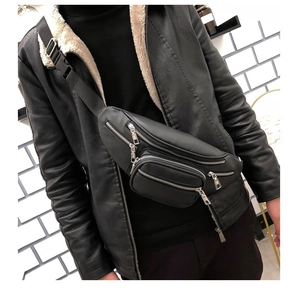 Detail of black leather chest bag with three zipper pockets and silver metal hardware