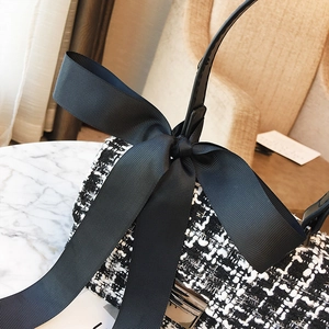 Classic black and white tweed crossbody bag with large bow detail and leather handle
