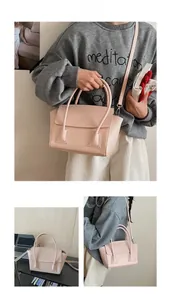 Detail of light pink crossbody bag showing detachable strap and metal hooks