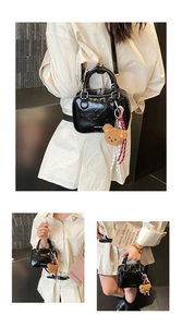 Vues détaillées d'un sac à main noir brillant avec un ours en peluche et ruban