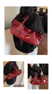 Detail view of red glossy leather tote bag showing zippers and metallic hardware parts