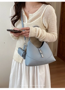 Close-up of light blue lychee pattern hobo bag with mini pouch and silver metal buckle