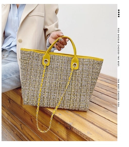 Detail view of large tweed tote bag with yellow leather trim and silver chain handles