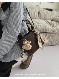 Deep brown crossbody bag with spiral handle and teddy bear charm on model