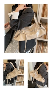 Detail view of beige leather hobo bag featuring silver hardware and decorative tassels