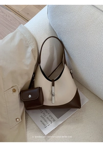 Detail of retro hobo bag with contrast stitching and attached mini pouch accessory