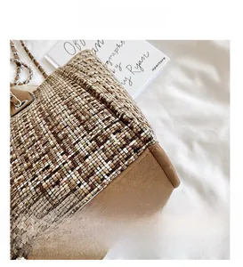 Macro detail of plaid tweed bucket bag showing woven texture and brown suede trim