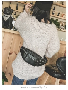 Détail d'un sac banane en cuir noir avec plusieurs poches et fermetures éclair argentées