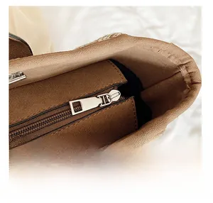 Detail shot of smooth silver zipper and suede lining on the brown bucket bag