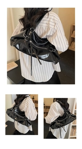 Close-up of black high-capacity crossbody bag featuring silver zippers and metallic rings
