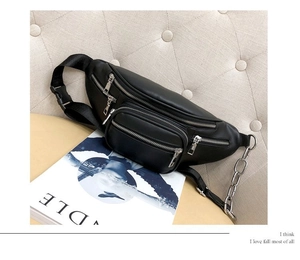 Close-up of black leather fanny pack with three zipper pockets and decorative chain