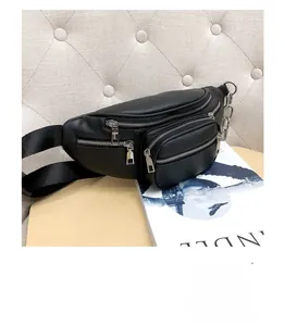 Detail of black faux leather fanny pack with silver zippers and stylish chain decoration