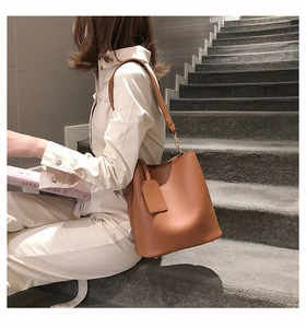 Détail du sac seau marron caramel au design trapèze avec bandoulière élégante