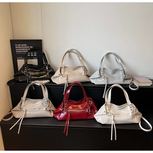 Detail showing five colors of leather handbags with metallic zippers and fringe tassels