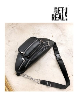 Detail view of black leather waist bag showing metal chains and adjustable strap