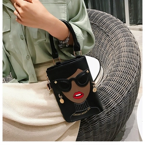 Détail d'un mini sac noir avec motif visage pop art, lunettes de soleil et lèvres