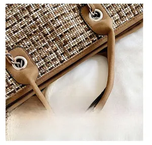 Detailed view of tri-color woven texture and suede handle with silver metal eyelets